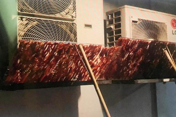 Raw meat being dried on air con vent outside Beach Road HDB flat